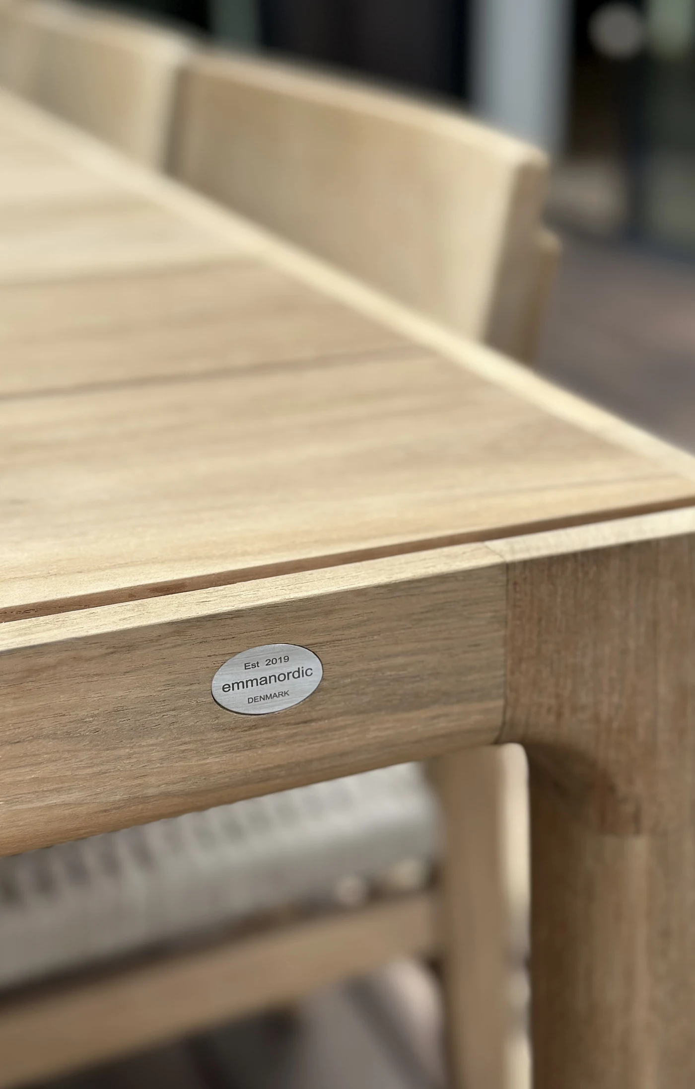 Detalje af Gath-bordets teak og Emmanordic-mærke